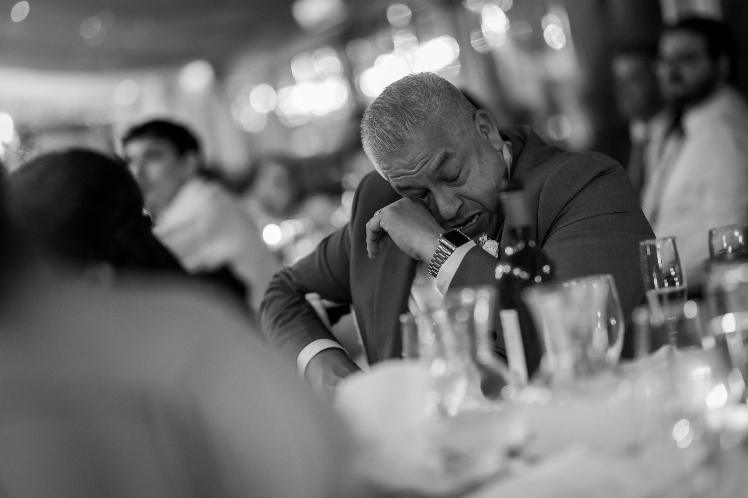 Black and white candid photo of guest at formal dinner reception.