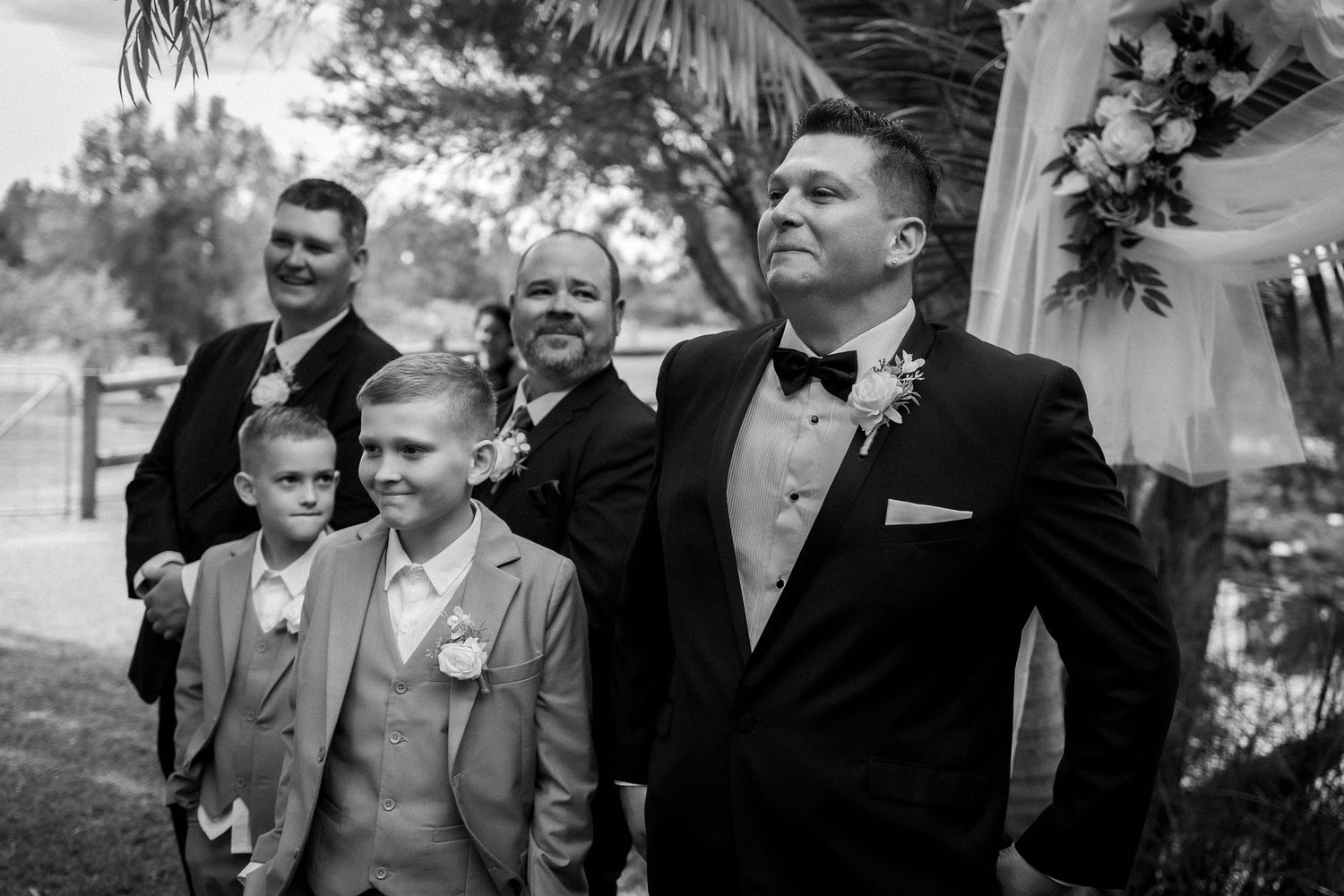 Wedding party members share joyful moments during an outdoor celebration.