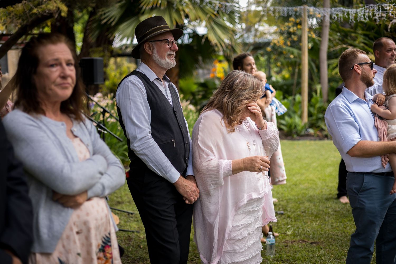 Wedding attendees celebrate during an outdoor garden reception.