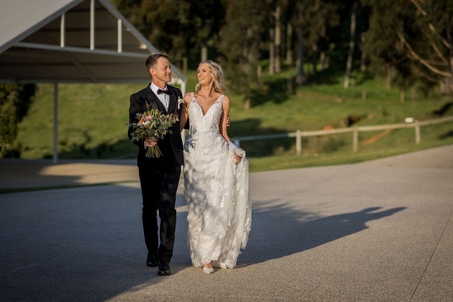 Wedding party walking along outdoor path during golden hour.