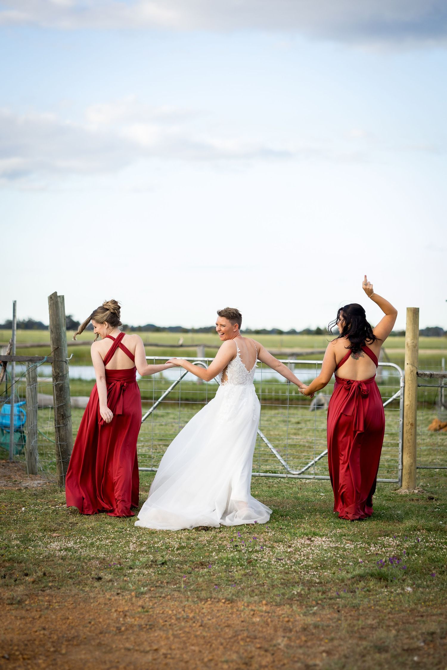 Fun photo sequence of bridal party doing dramatic poses in a field with white fence posts.