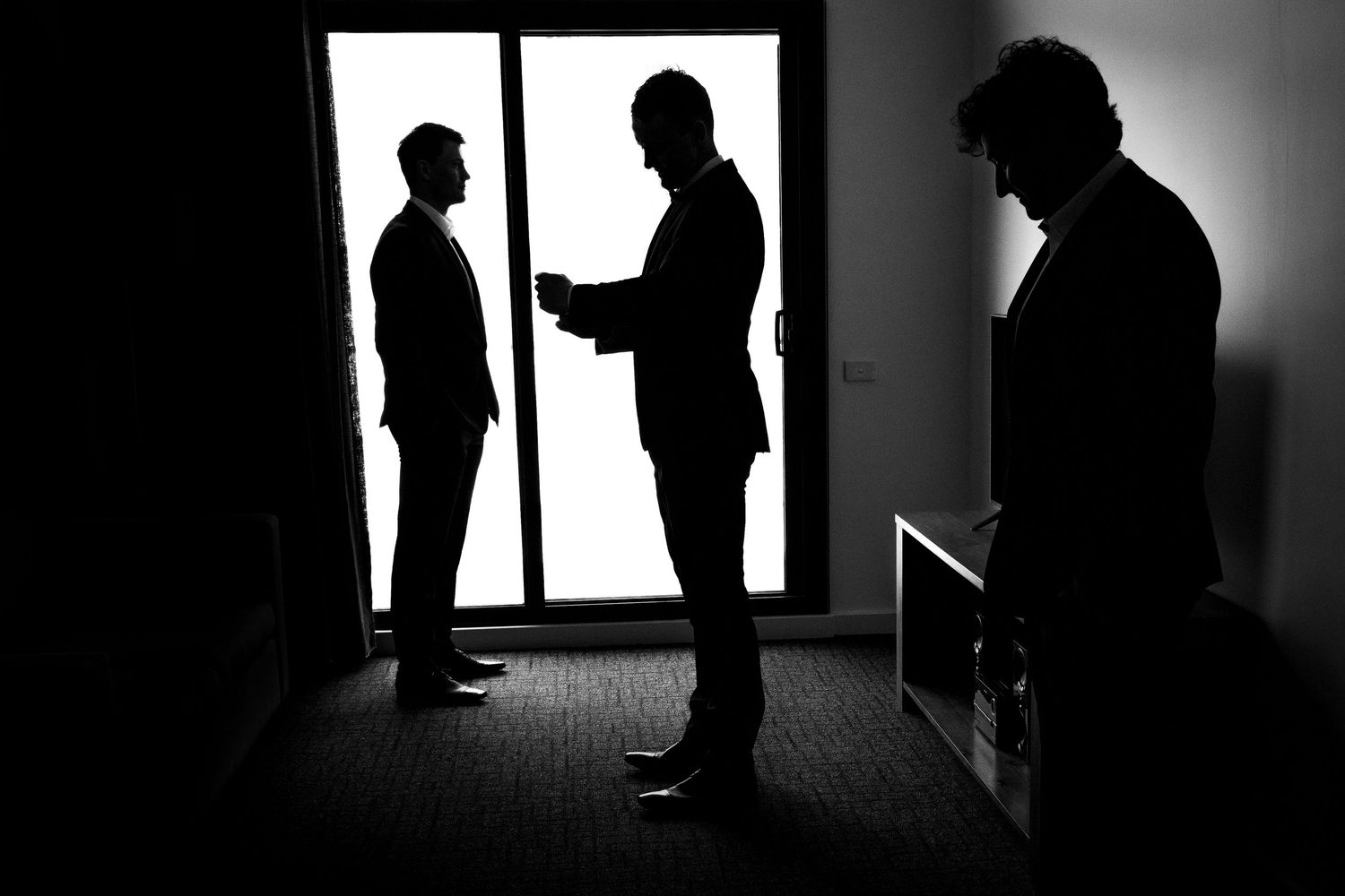 Dramatic silhouettes of people against bright windows create an artistic composition.