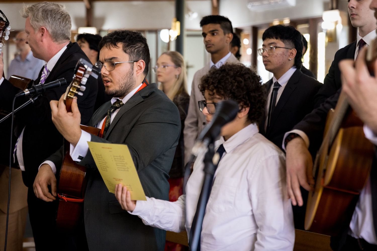 Musicians performing at formal event with instruments and sheet music.