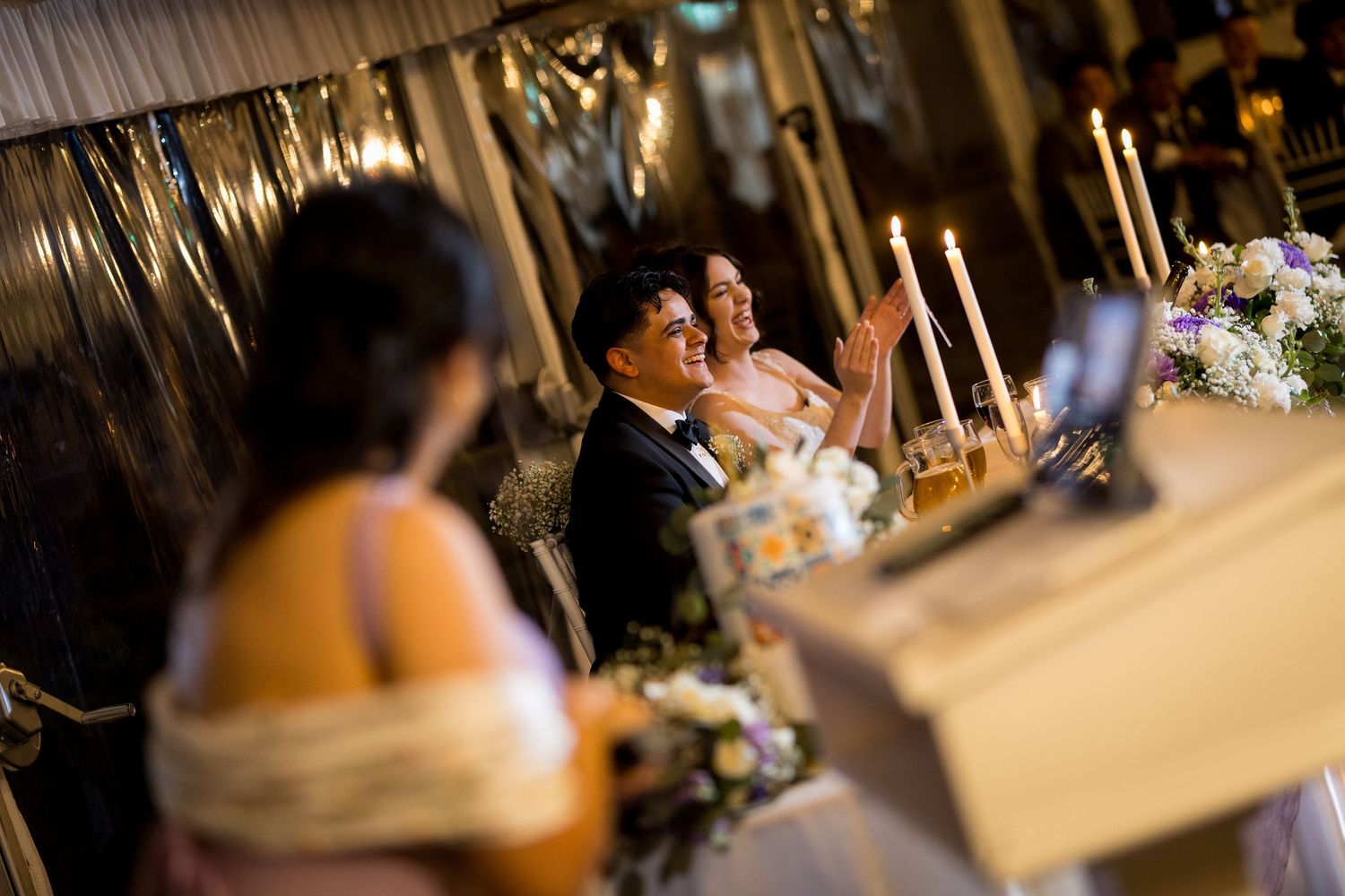 Wedding reception venue with elegant table settings and soft lighting.