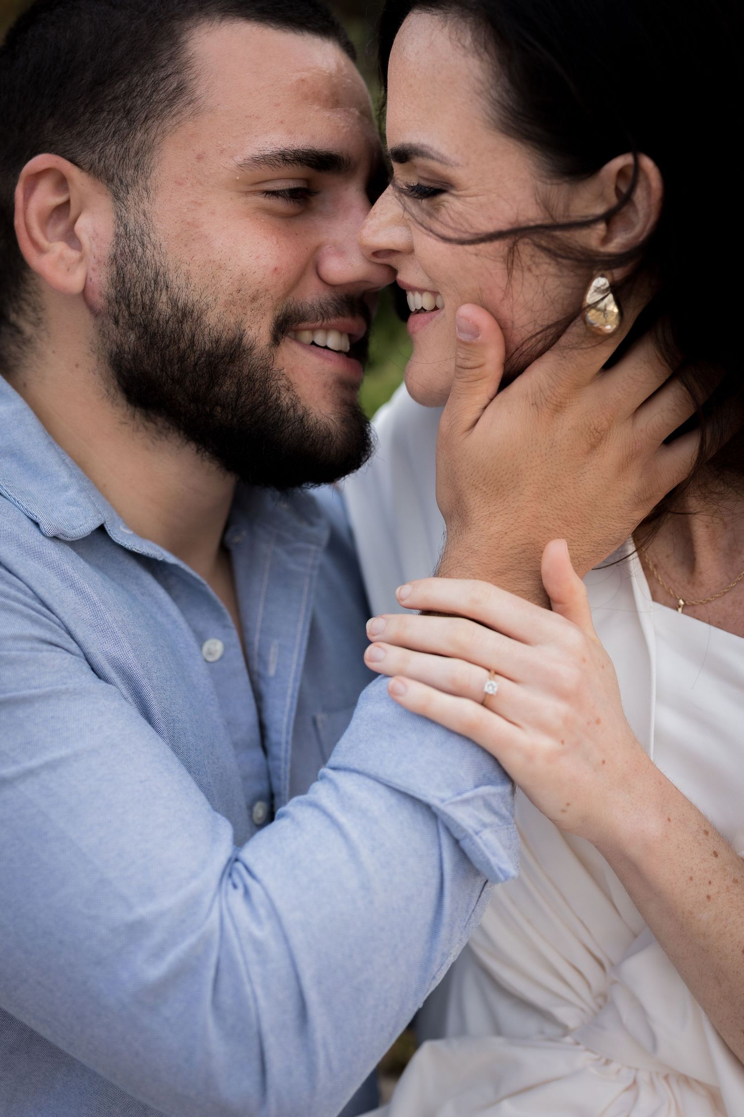 Smiling bearded man and woman sharing tender close moment outdoors.