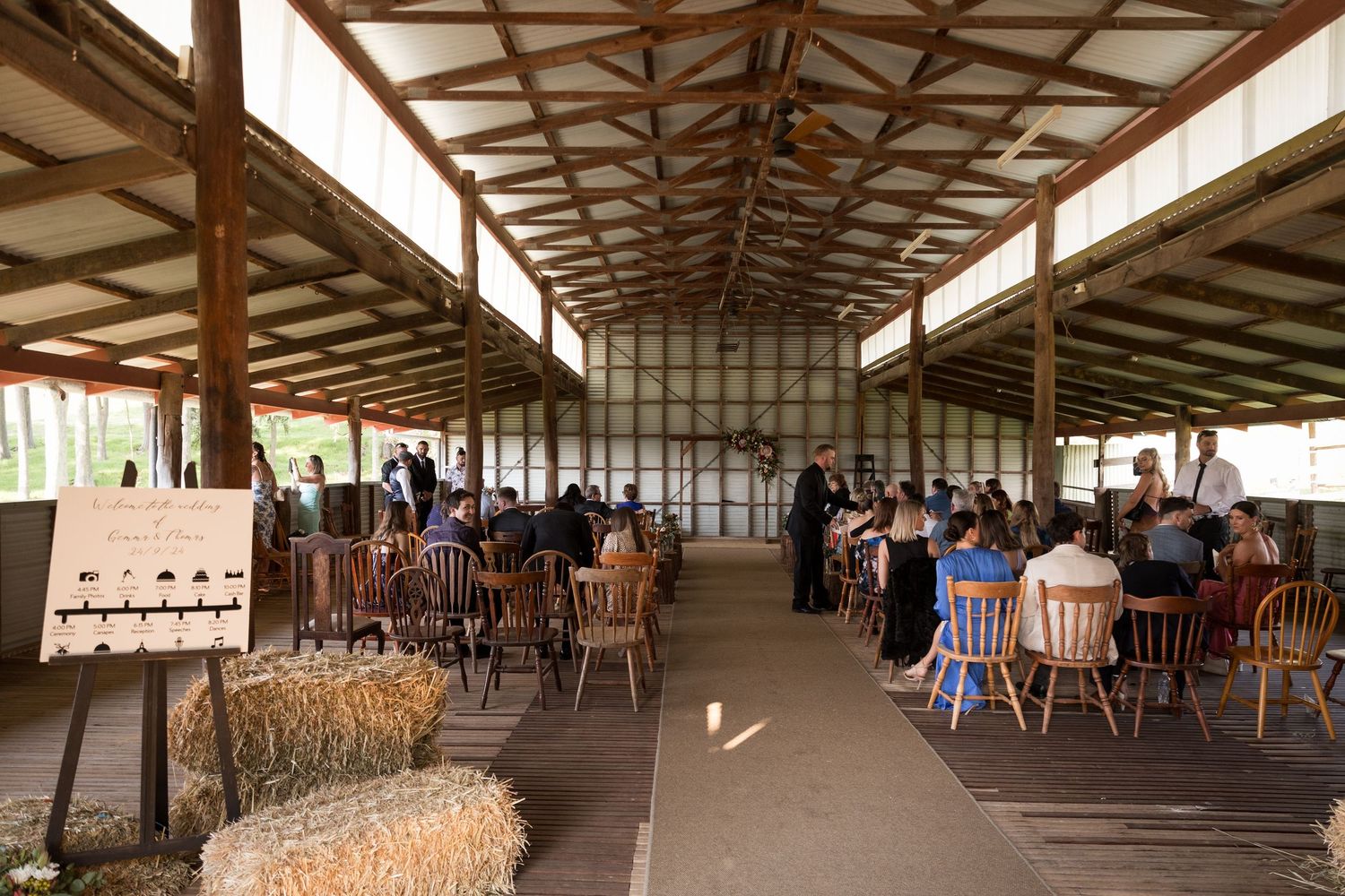 Rustic barn wedding venue with exposed wooden beams and natural lighting.