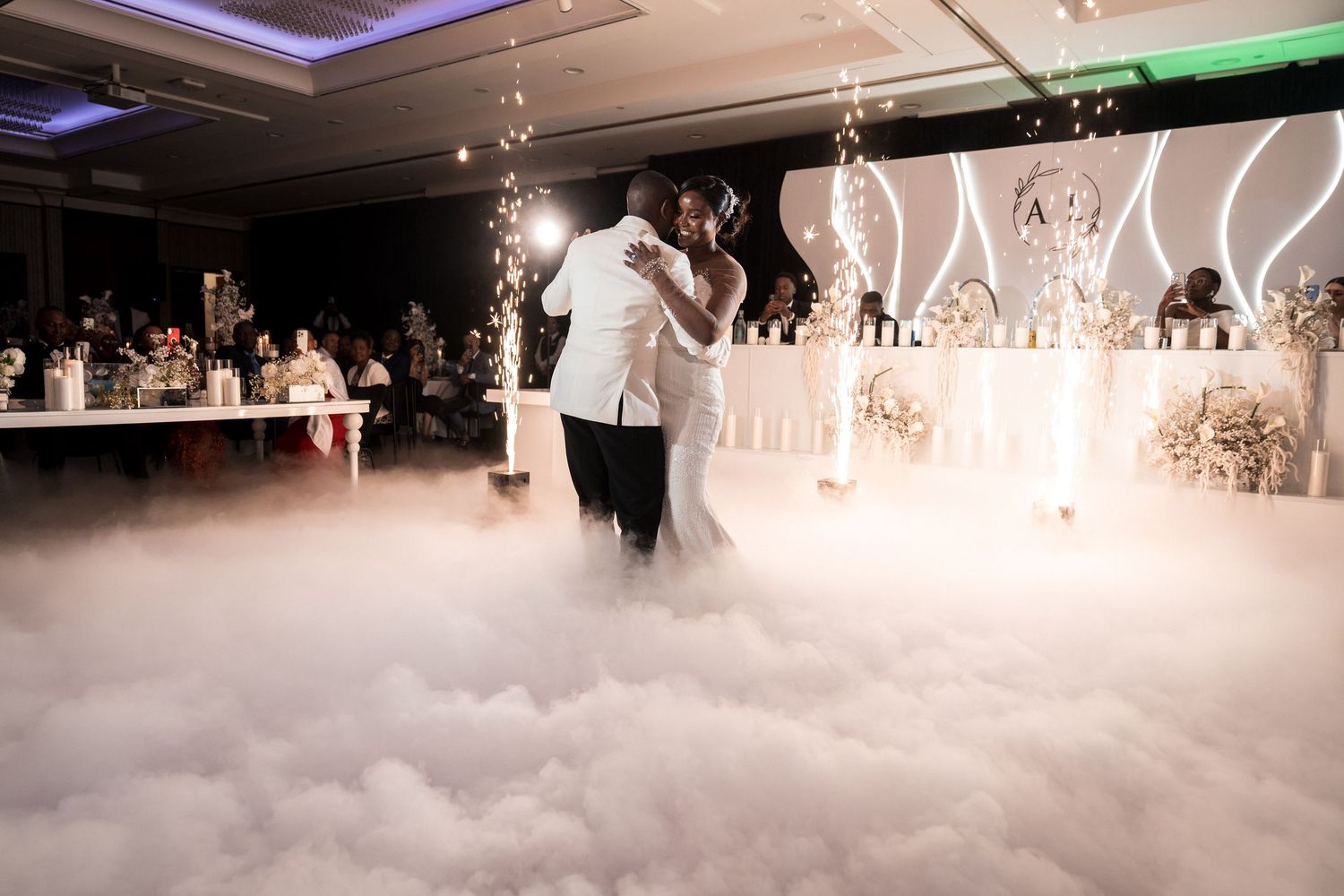Couple shares their first dance surrounded by dramatic dry ice fog at a elegant wedding reception.