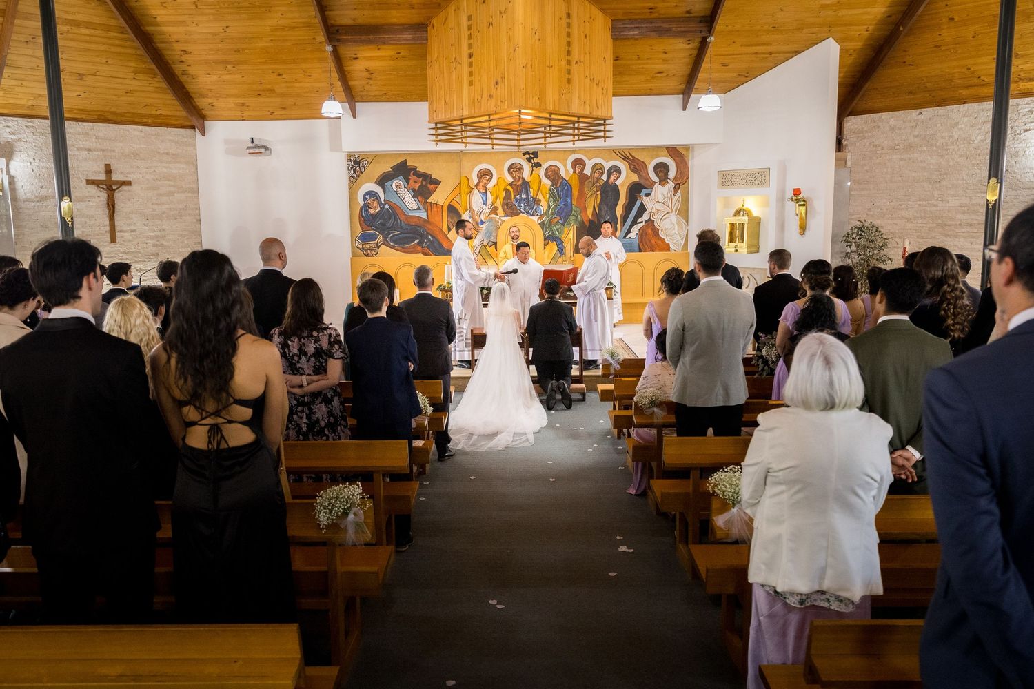 Panoramic view of a church wedding ceremony with wooden architecture and natural lighting.