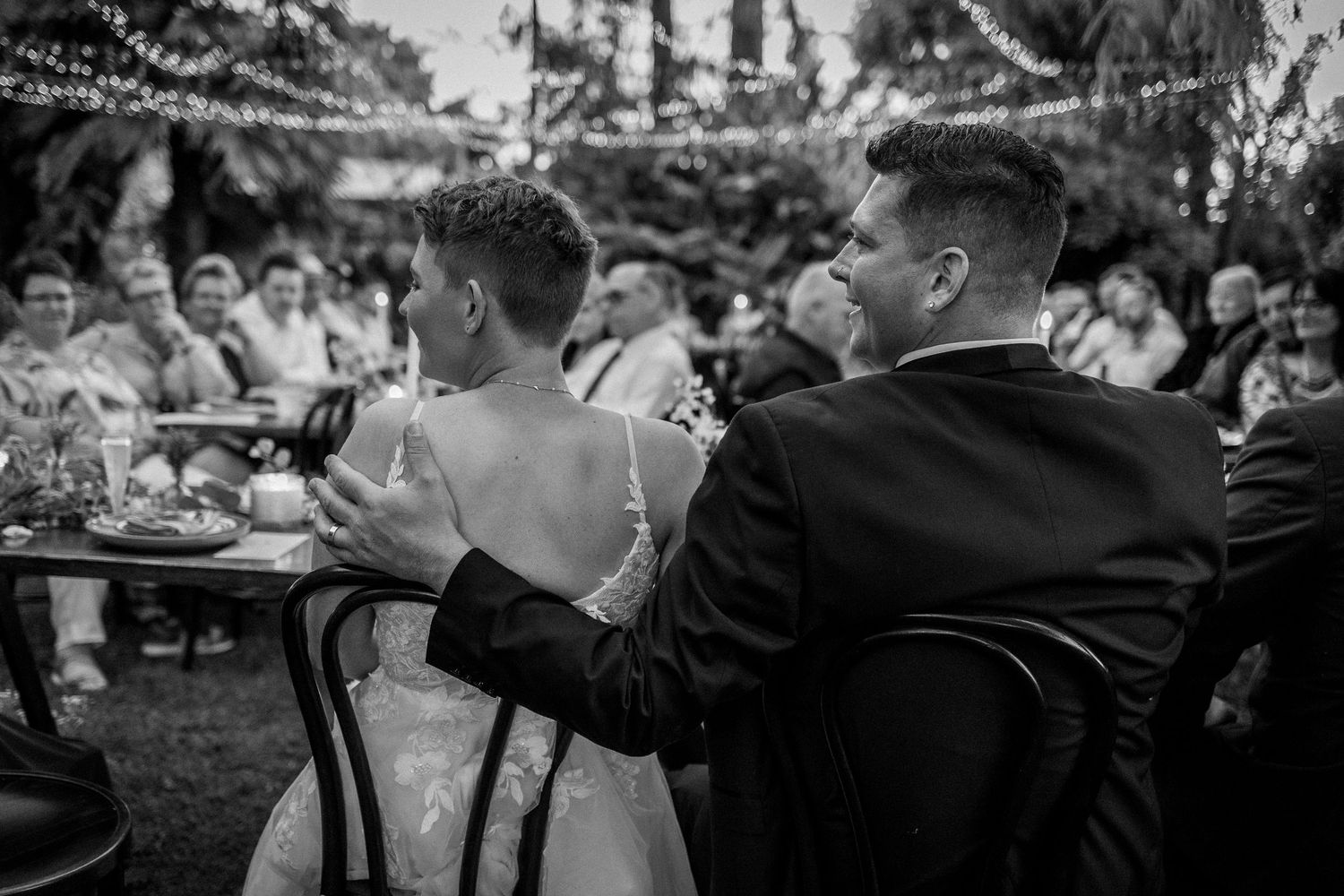 Black and white candid shots of wedding reception guests enjoying the celebration.