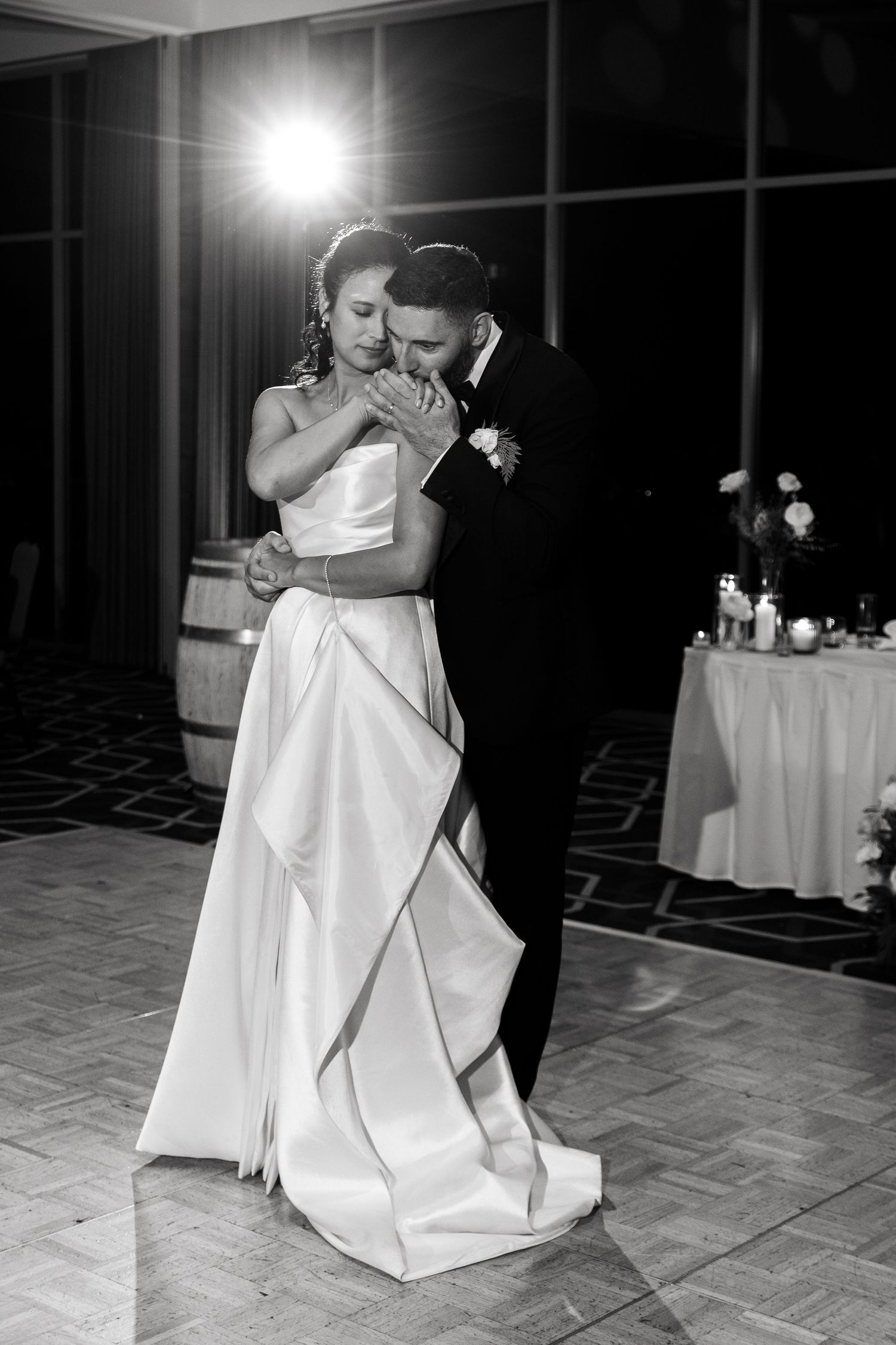 Black and white photo of bride and groom sharing an emotional first dance at their wedding reception.