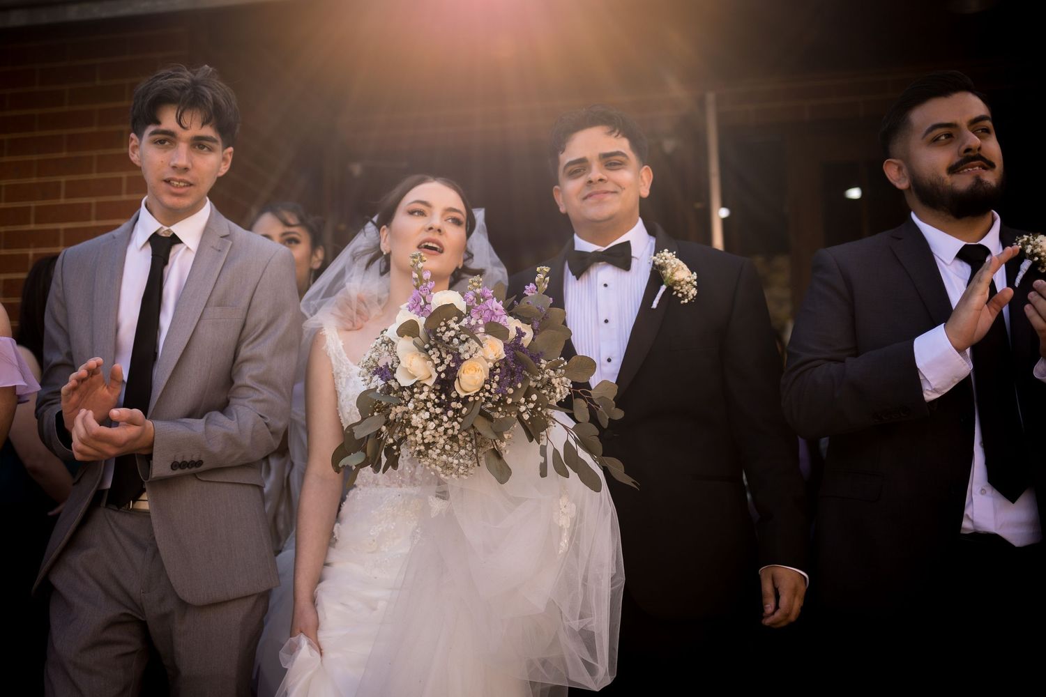Wedding celebration with guests dancing and celebrating in evening lighting.