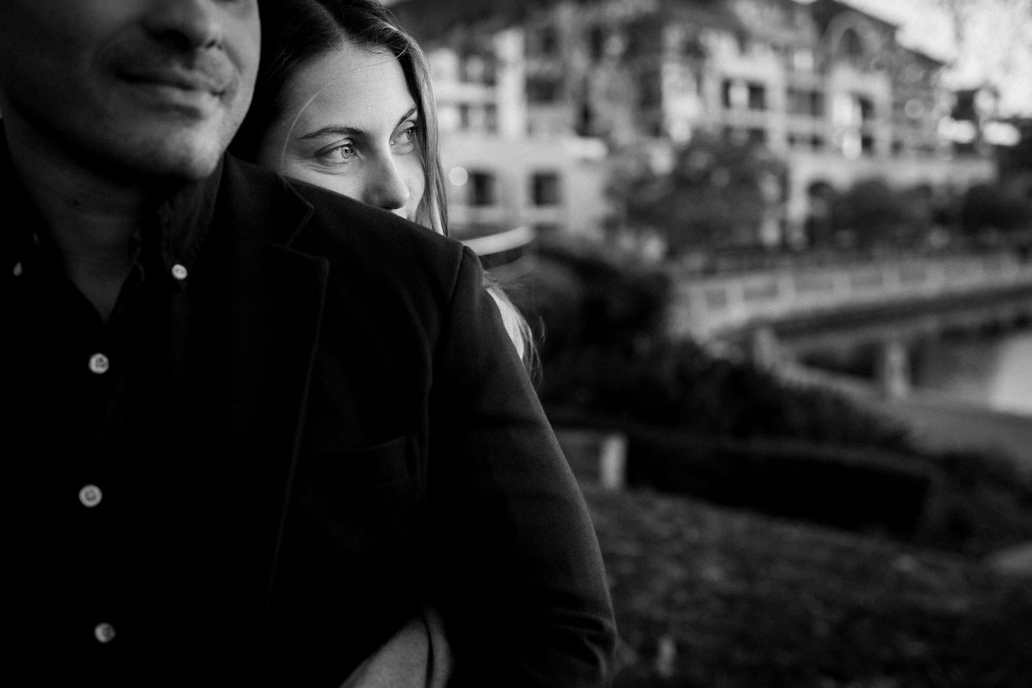 Close-up portrait composition with urban buildings in soft focus background.