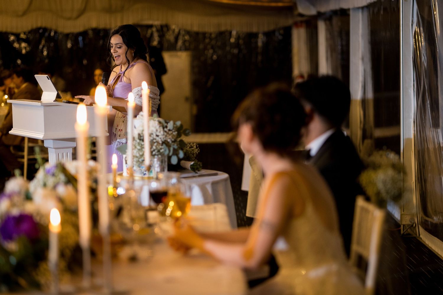 Intimate wedding reception scene with glowing candles and table decorations.