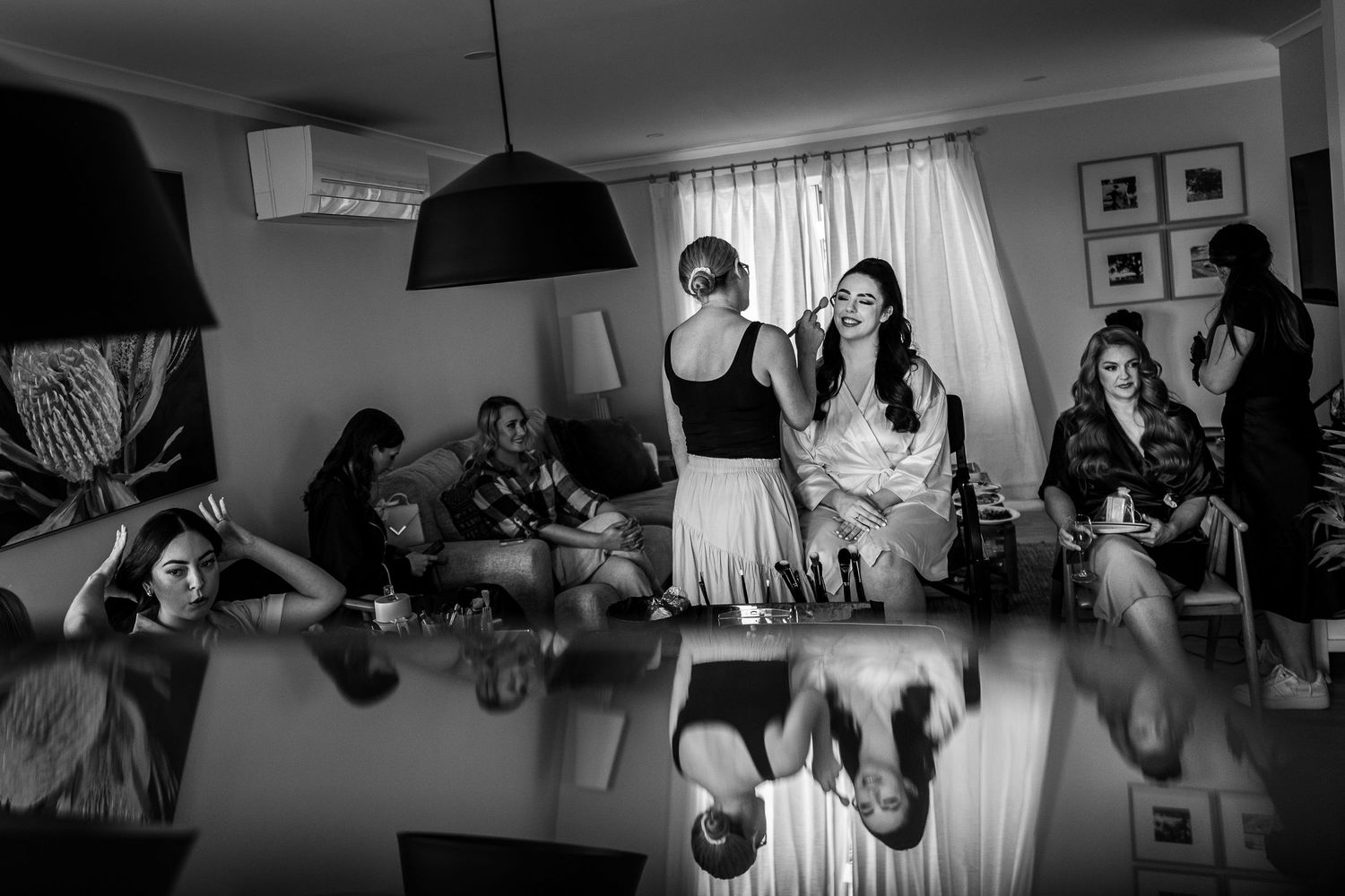 Wedding party gathered indoors with natural light streaming through windows.