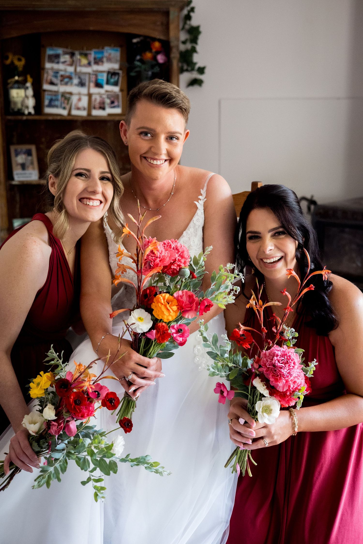 Wedding party members holding vibrant bouquets with pink and orange flowers.
