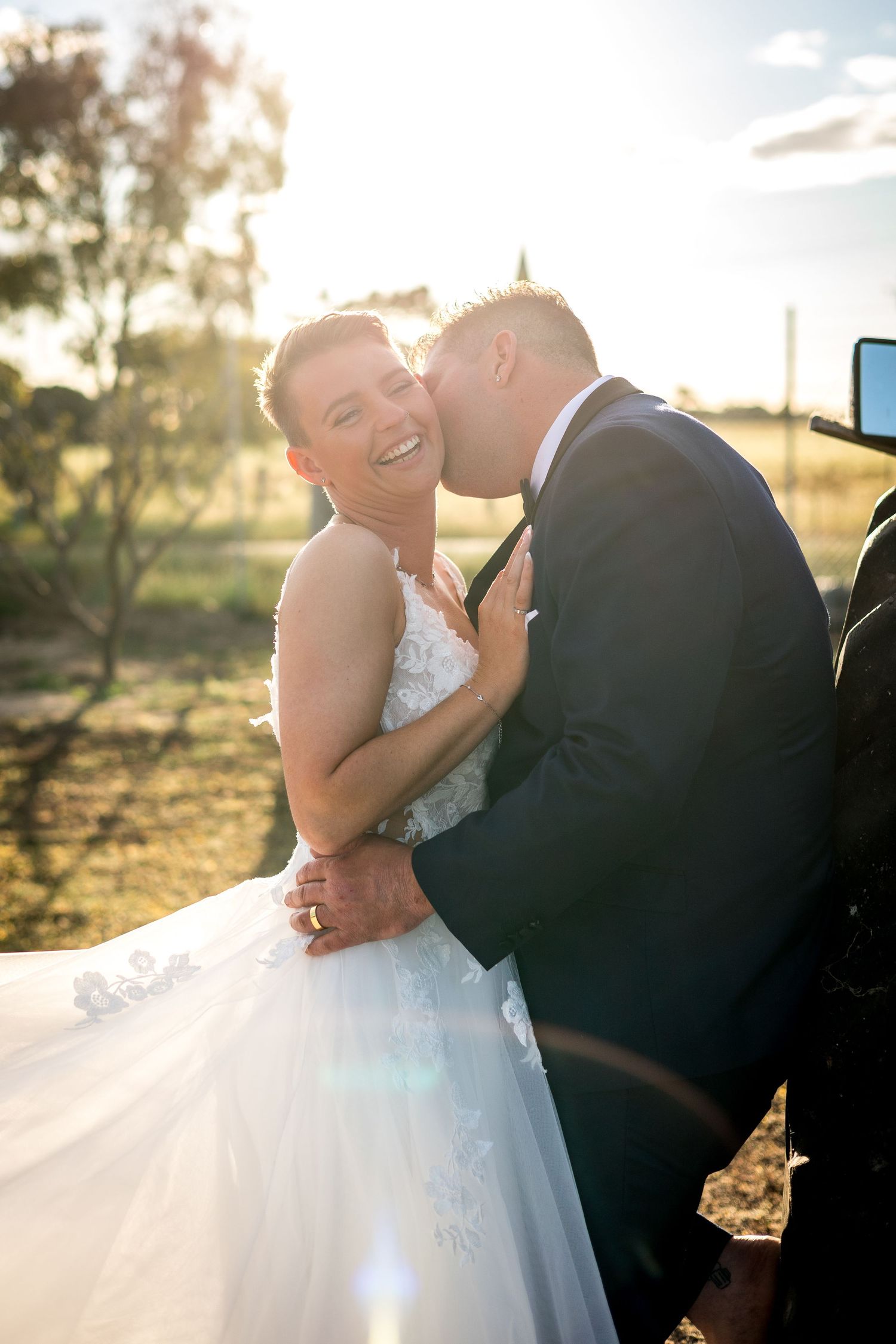 Romantic sunset portraits of newlyweds sharing intimate moments in golden light.