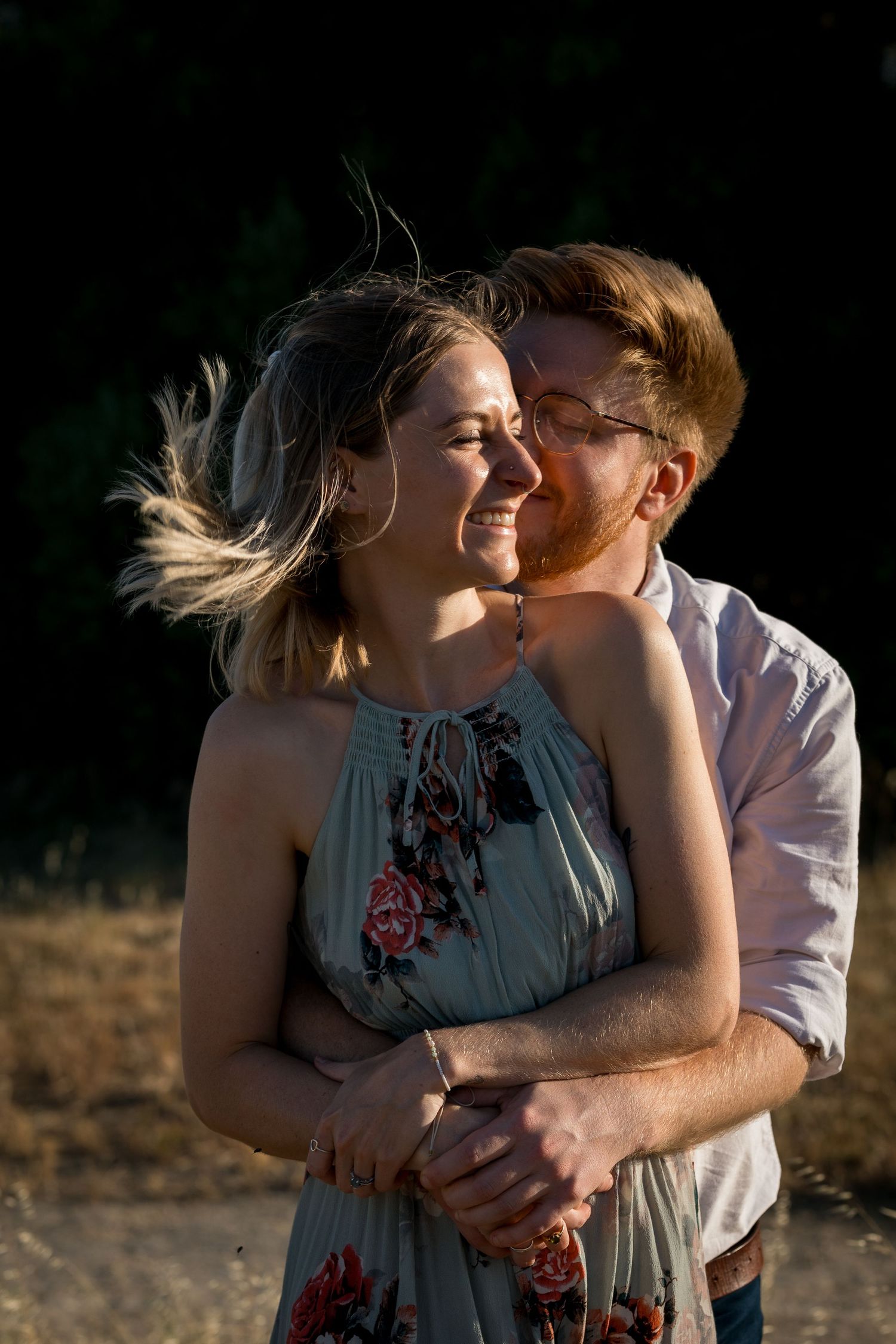 An intimate moment shared between a couple in dramatic lighting against a dark background.