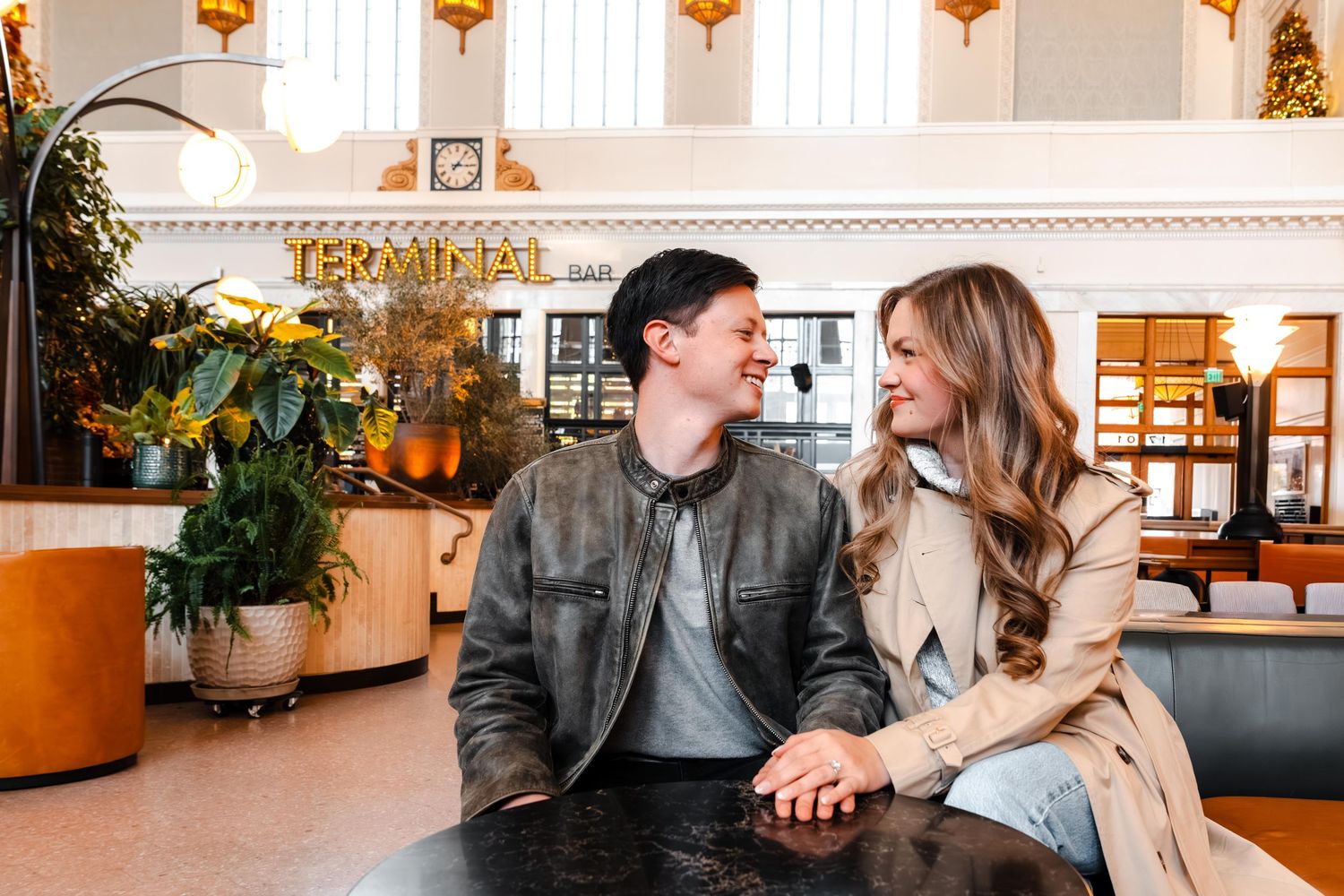 Couple smiles at each other while seated at table inside Terminal Bar restaurant venue.