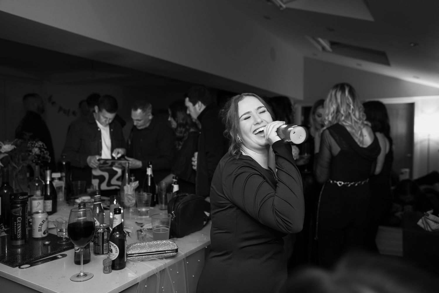 Wide shot of a dark party venue with people dancing and celebrating.
