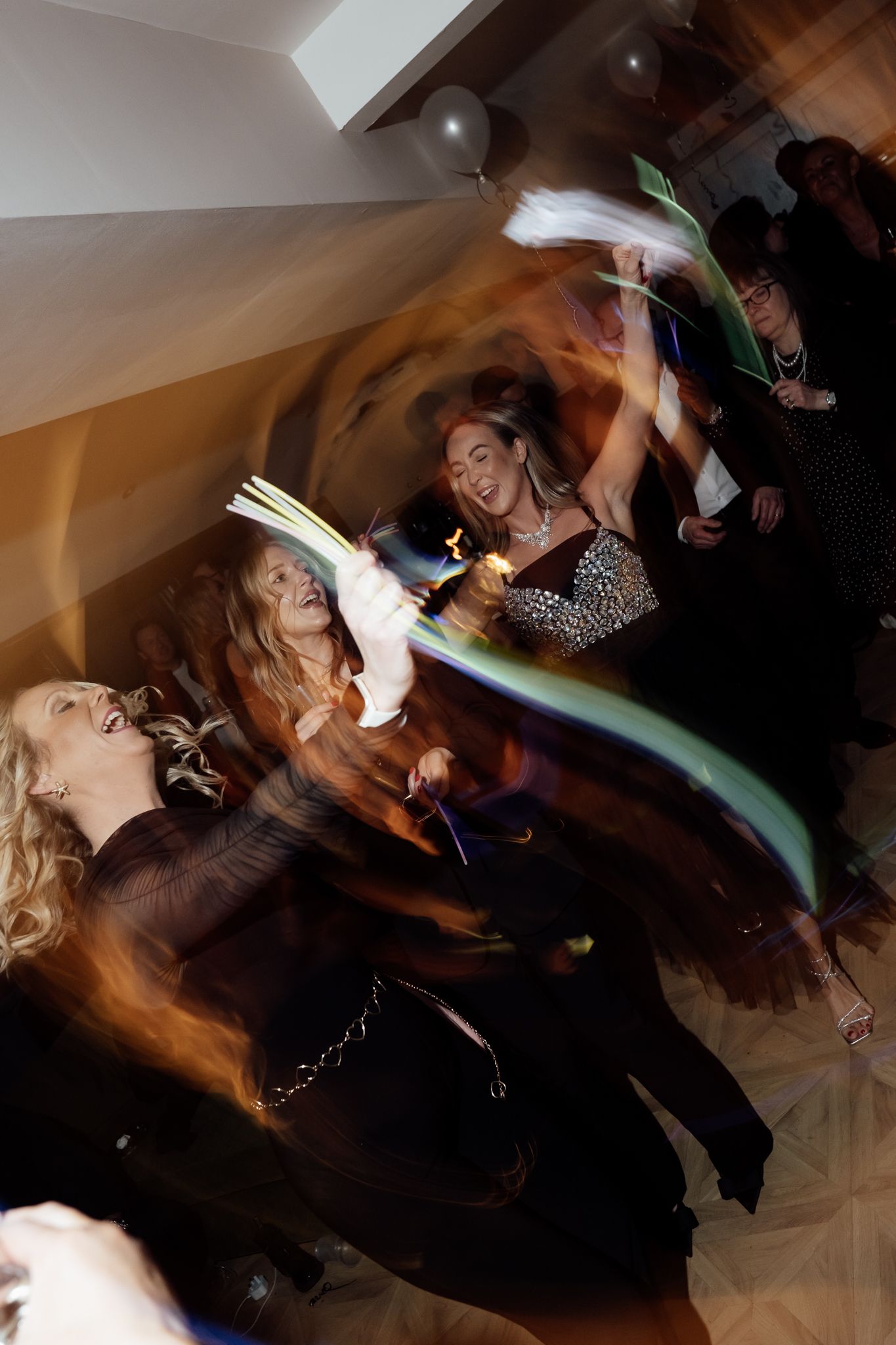 Motion-blurred images capture dancers moving energetically at a nighttime party.