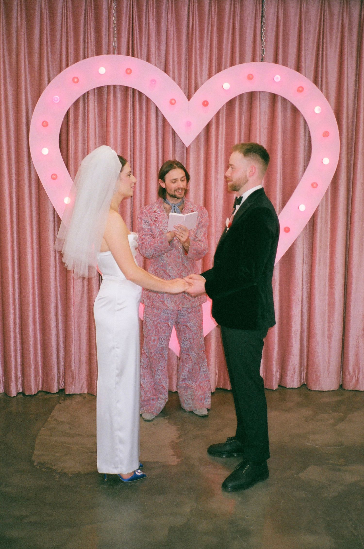 Four sequential photos show couples dancing together in front of a pink curtain backdrop at a formal event.