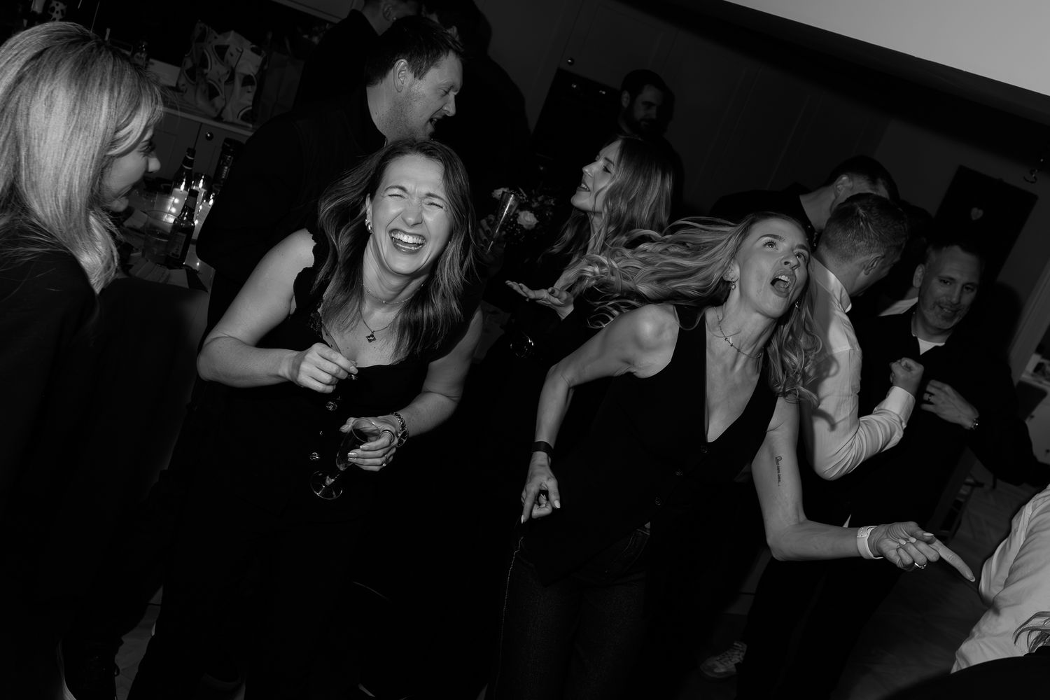 Guests enjoying themselves on a crowded dance floor at night.