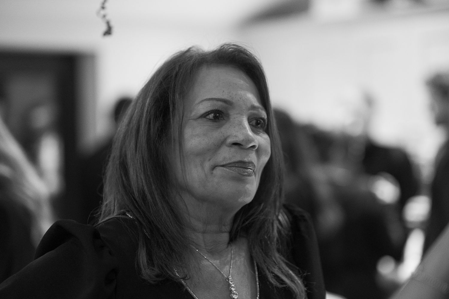 Candid black and white shots of party guests enjoying themselves at an indoor celebration.