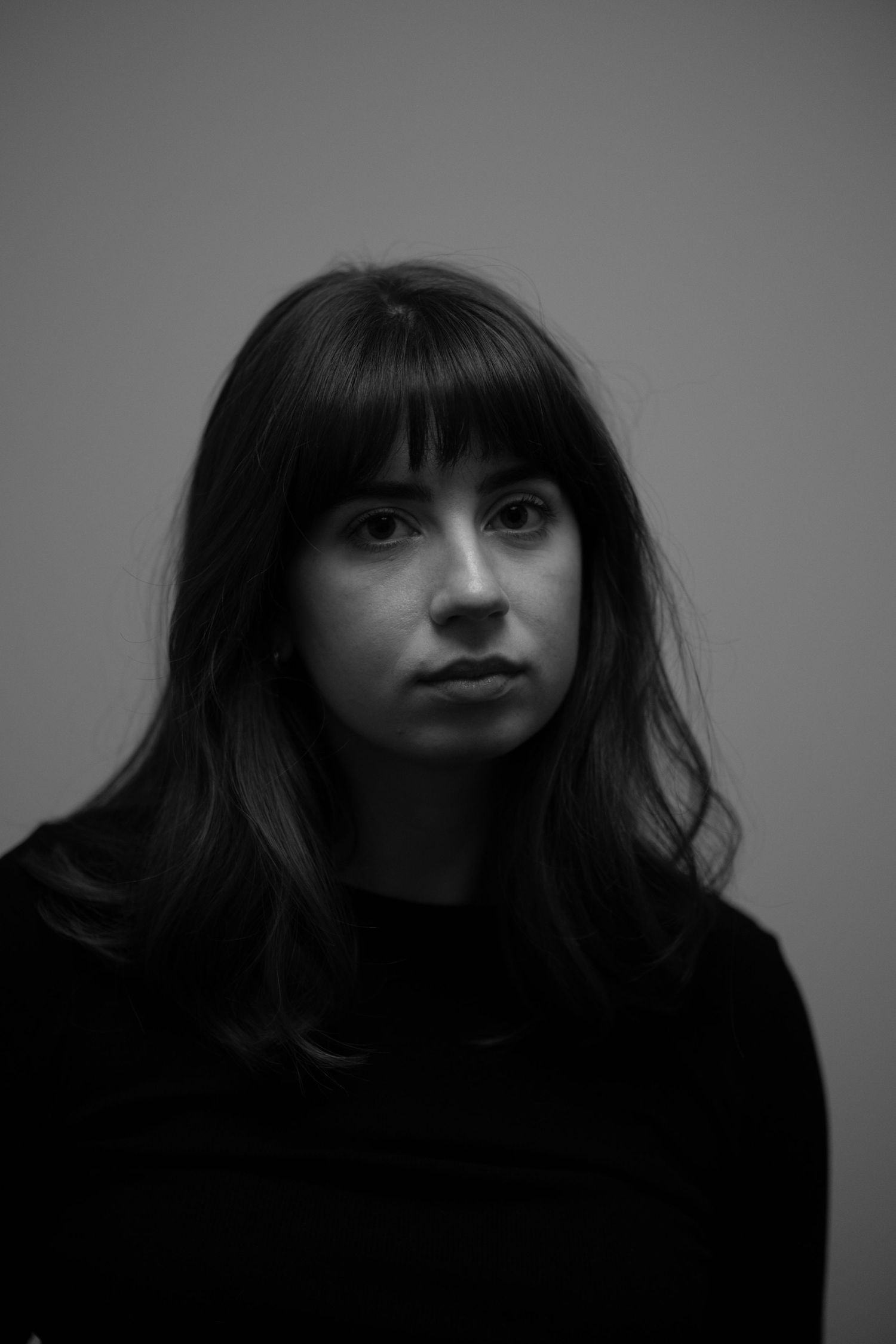 A black and white portrait series showing dramatic lighting on dark hair and facial features in moody tones.