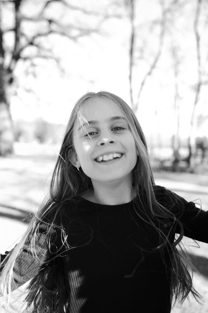 Black and white photo sequence showing joyful expressions and flowing hair movement in an outdoor setting.