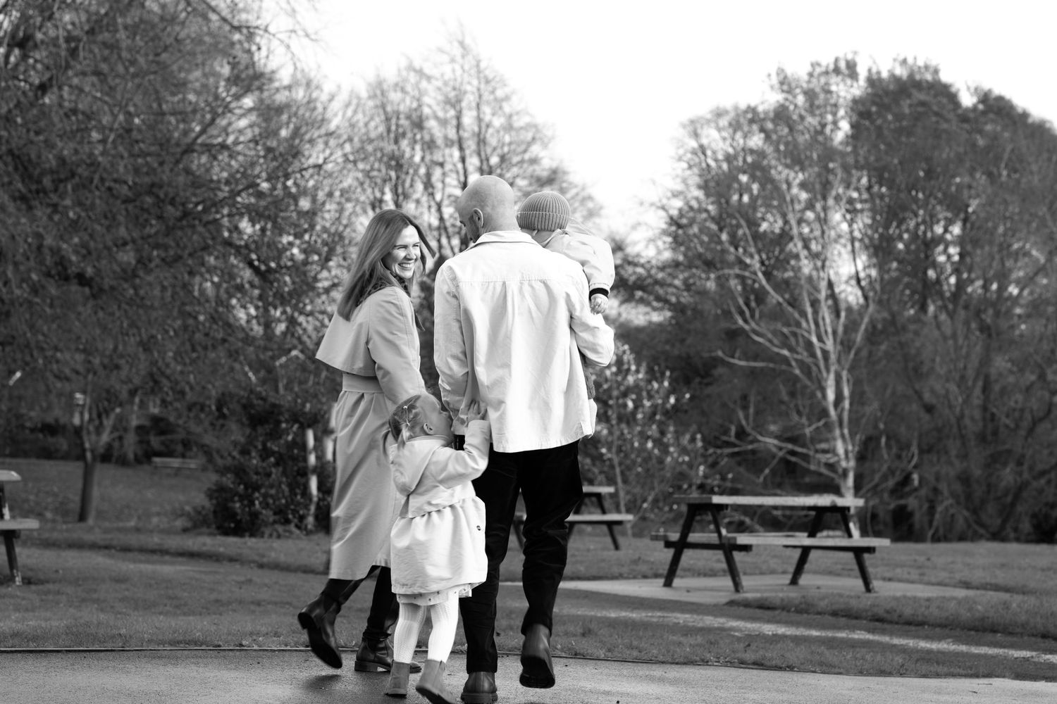 Elderly couple walking together in a park on a sunny day, holding hands and enjoying a peaceful moment together.