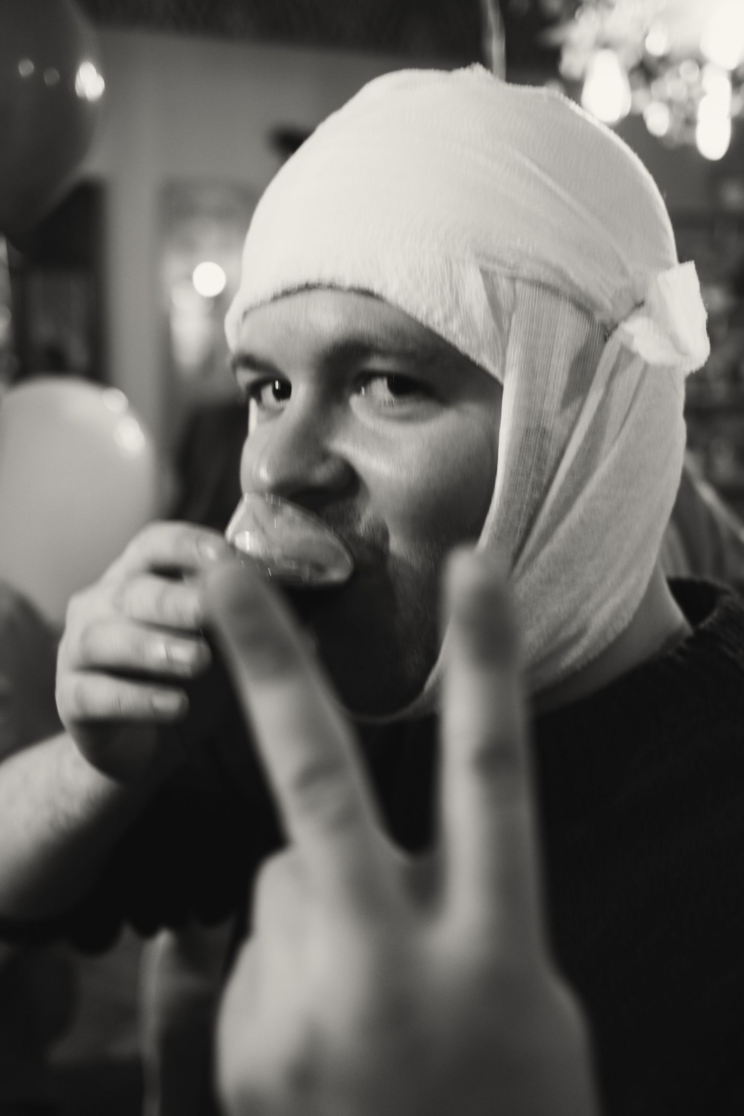 A series of black and white photos showing someone applying medical bandages to their face in a sequential progression.