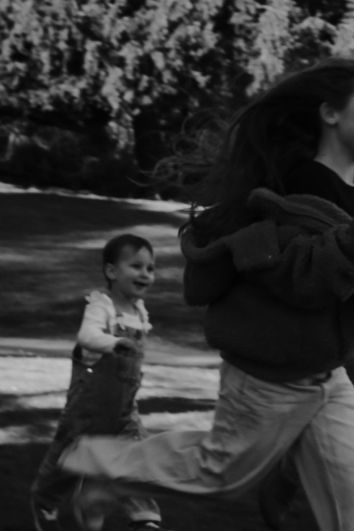 A black and white vintage photograph showing two people in casual clothing playing outdoors.