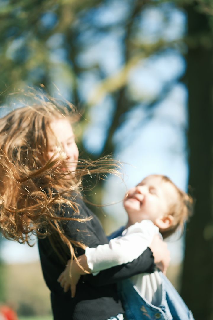 A sequence showing a person's hair dramatically whipping through the air against a blurred natural background.