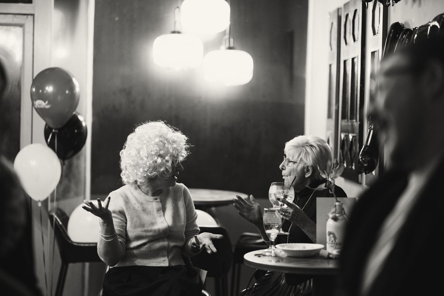 A series of black and white photographs showing a person sitting at a table in a dimly lit room.