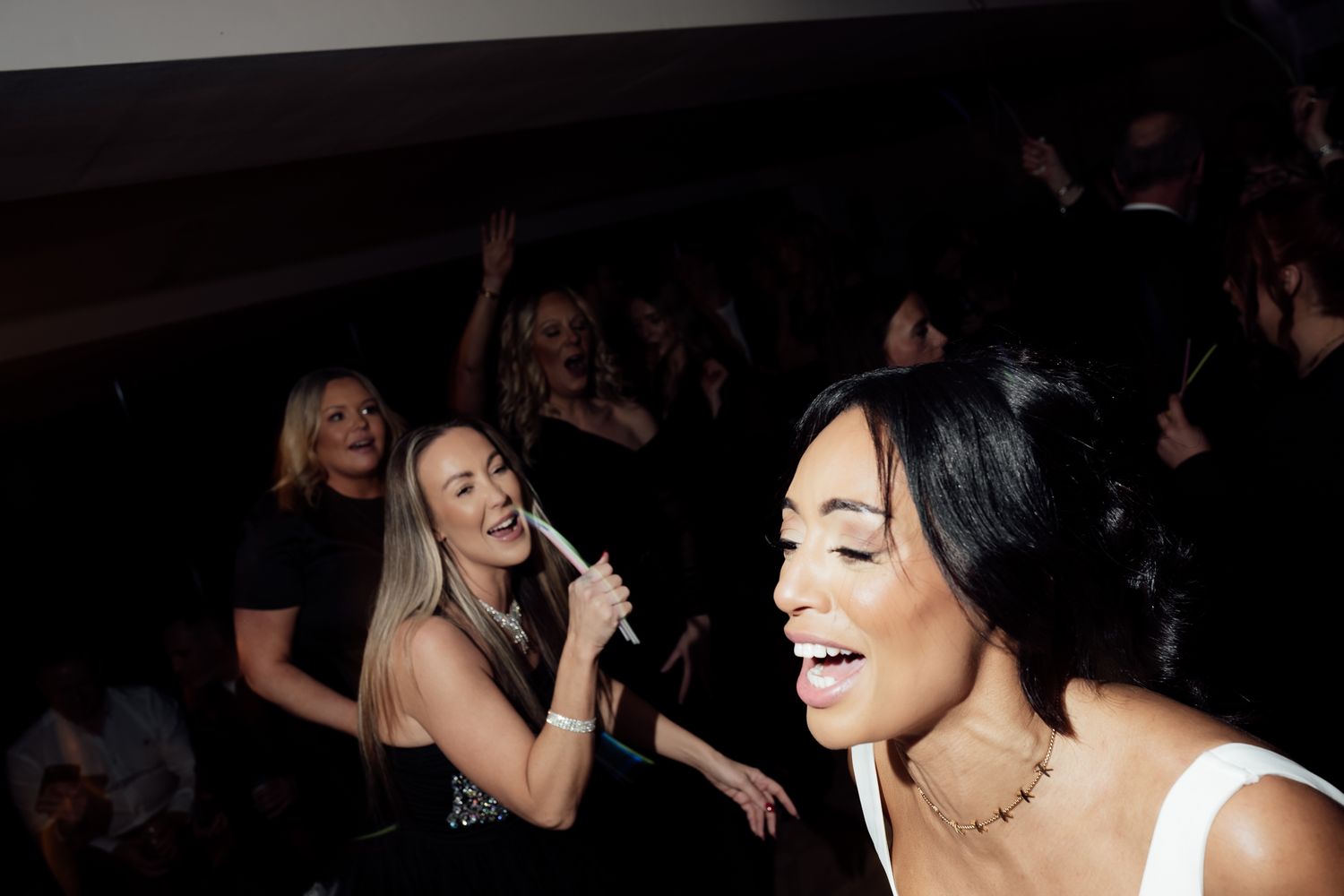 A group of people dancing and enjoying themselves at a lively party or celebration.