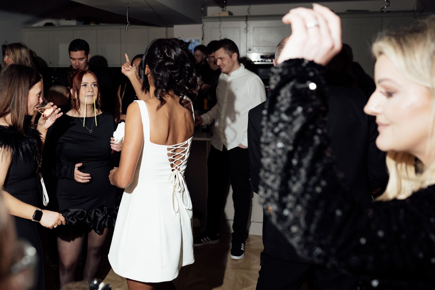 People dancing and socializing at a dimly lit party venue.