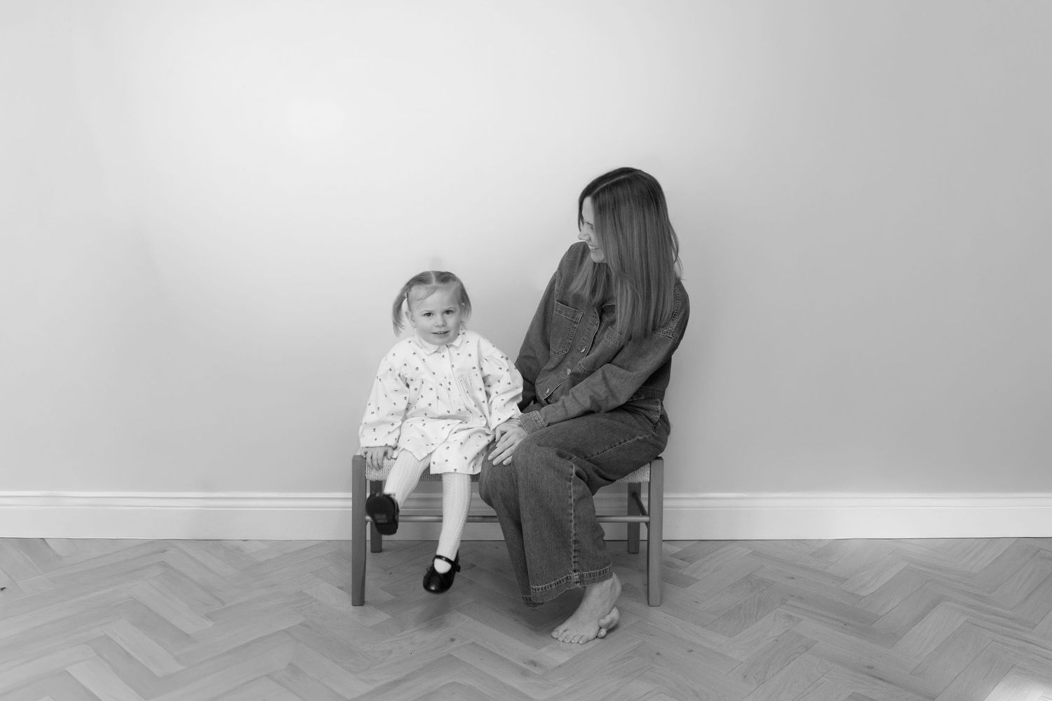 A black and white photo series showing a child and adult sitting in various poses and positions.