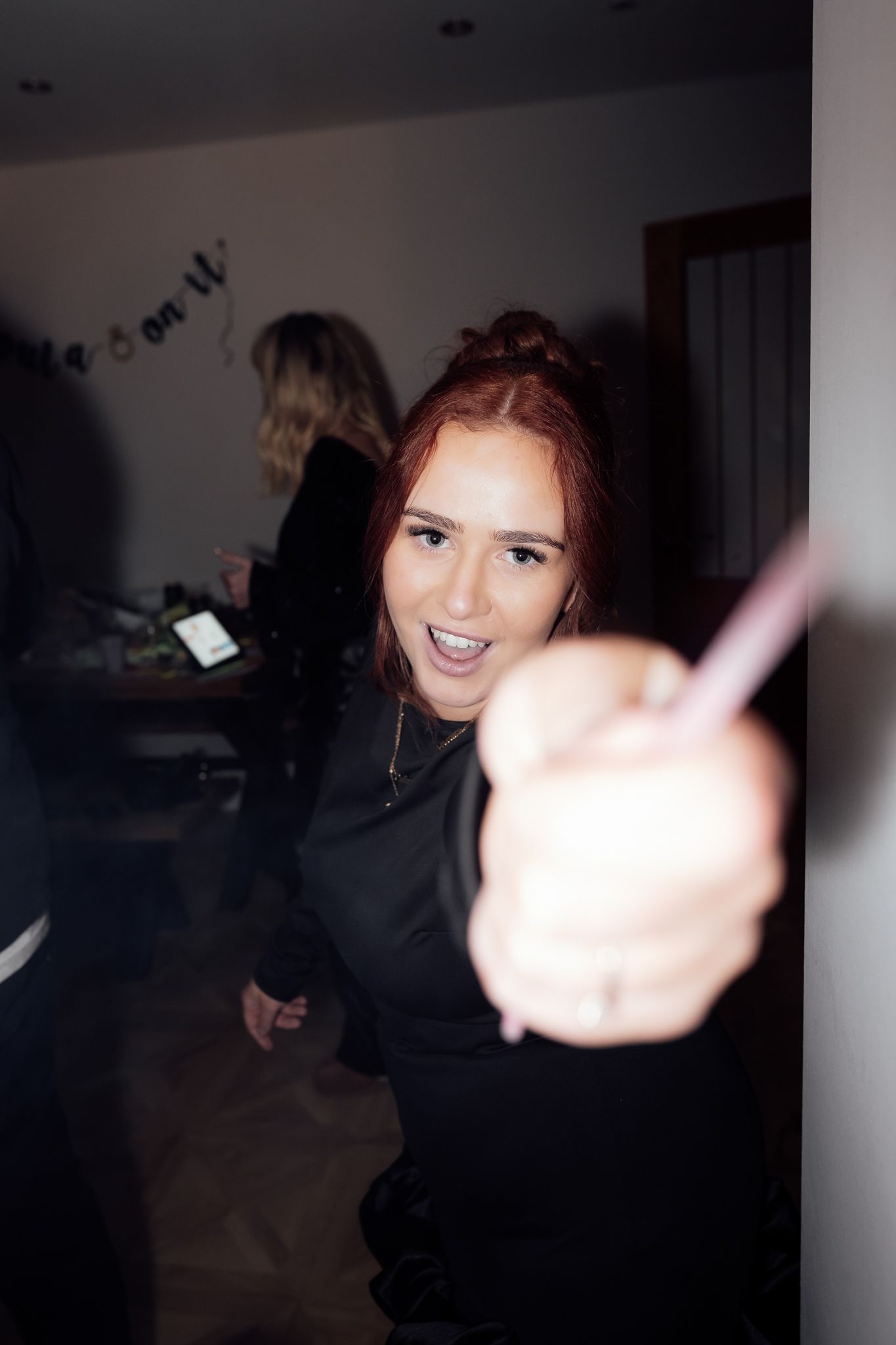 A party guest giving thumbs up while smiling at the camera during a nighttime celebration.