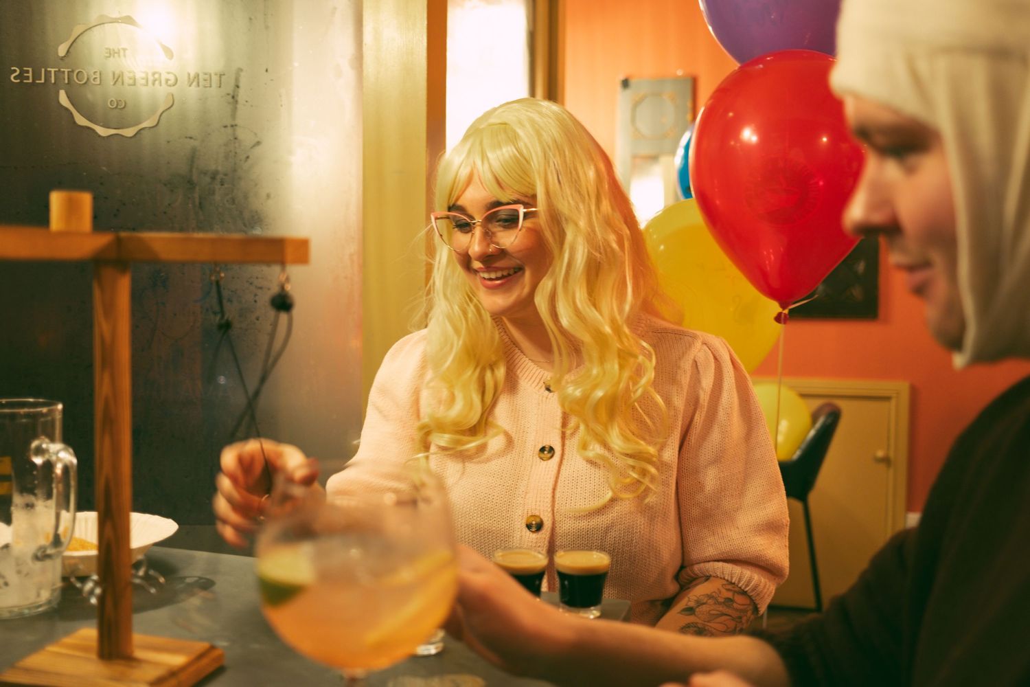 A series of warm-toned party scenes with colorful balloons and festive lighting in an indoor setting.