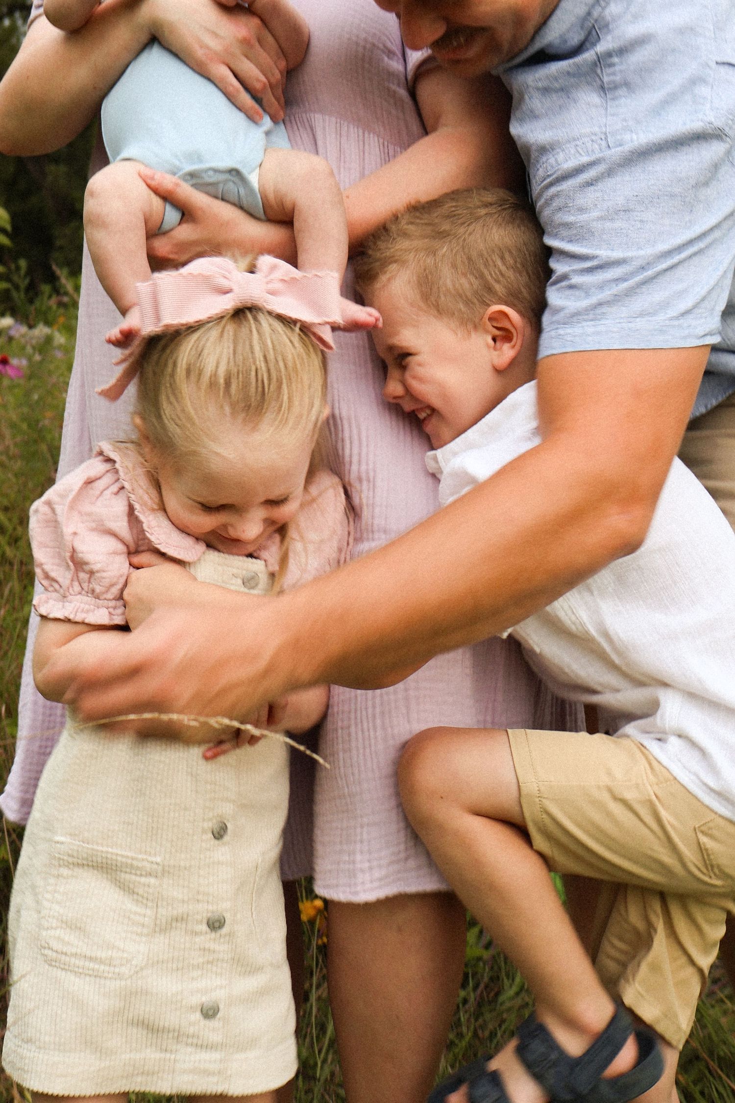 A tender family moment captured outdoors with children embracing.
