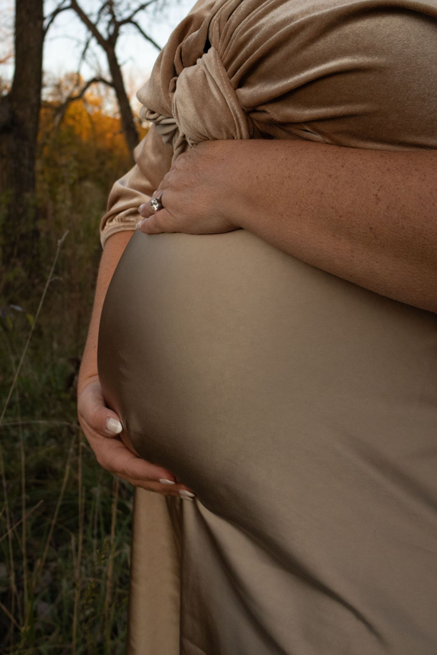 A series of close-up shots showing the progression of a pregnant belly in a brown maternity dress.