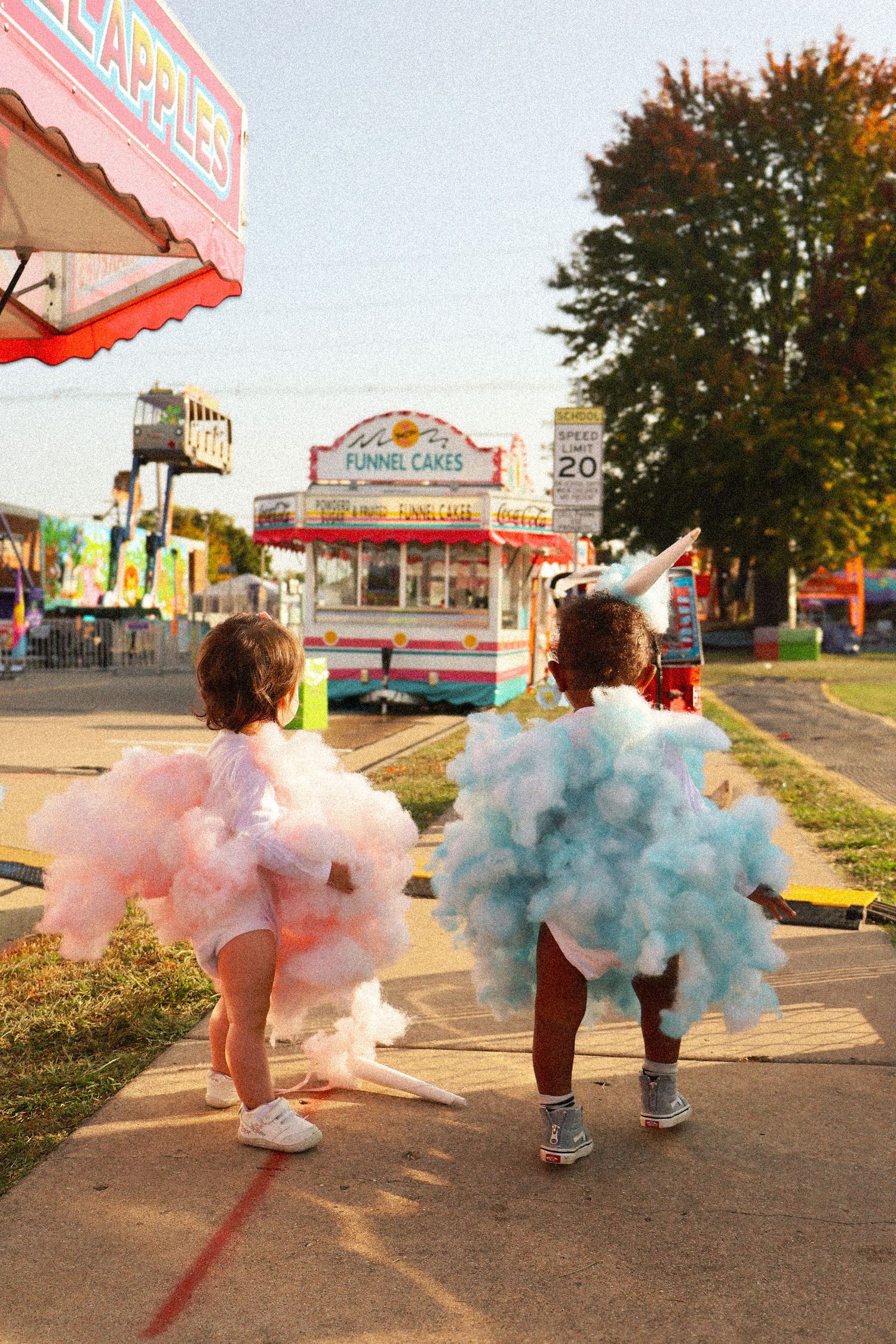 Pink and blue smoke effects create dreamy atmosphere outside a carnival fairground.
