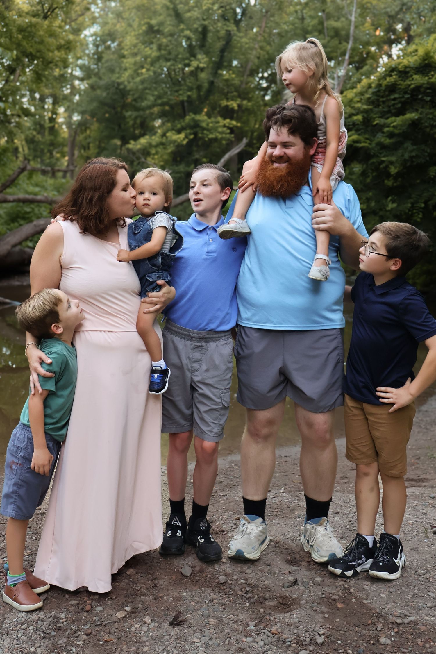 Family group posing casually together outdoors in coordinated outfits.