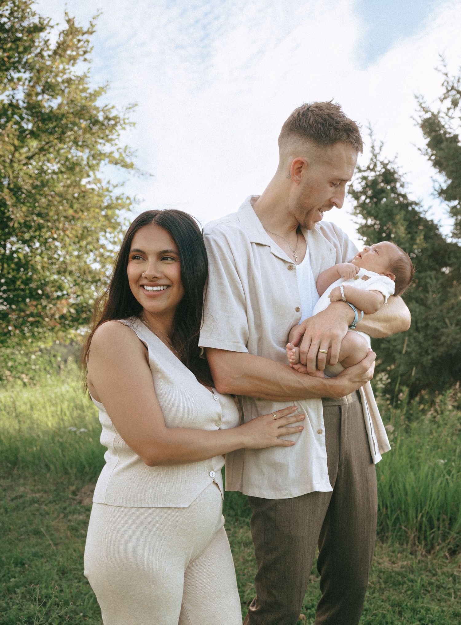 A maternity photoshoot series outdoors with natural greenery in the background.