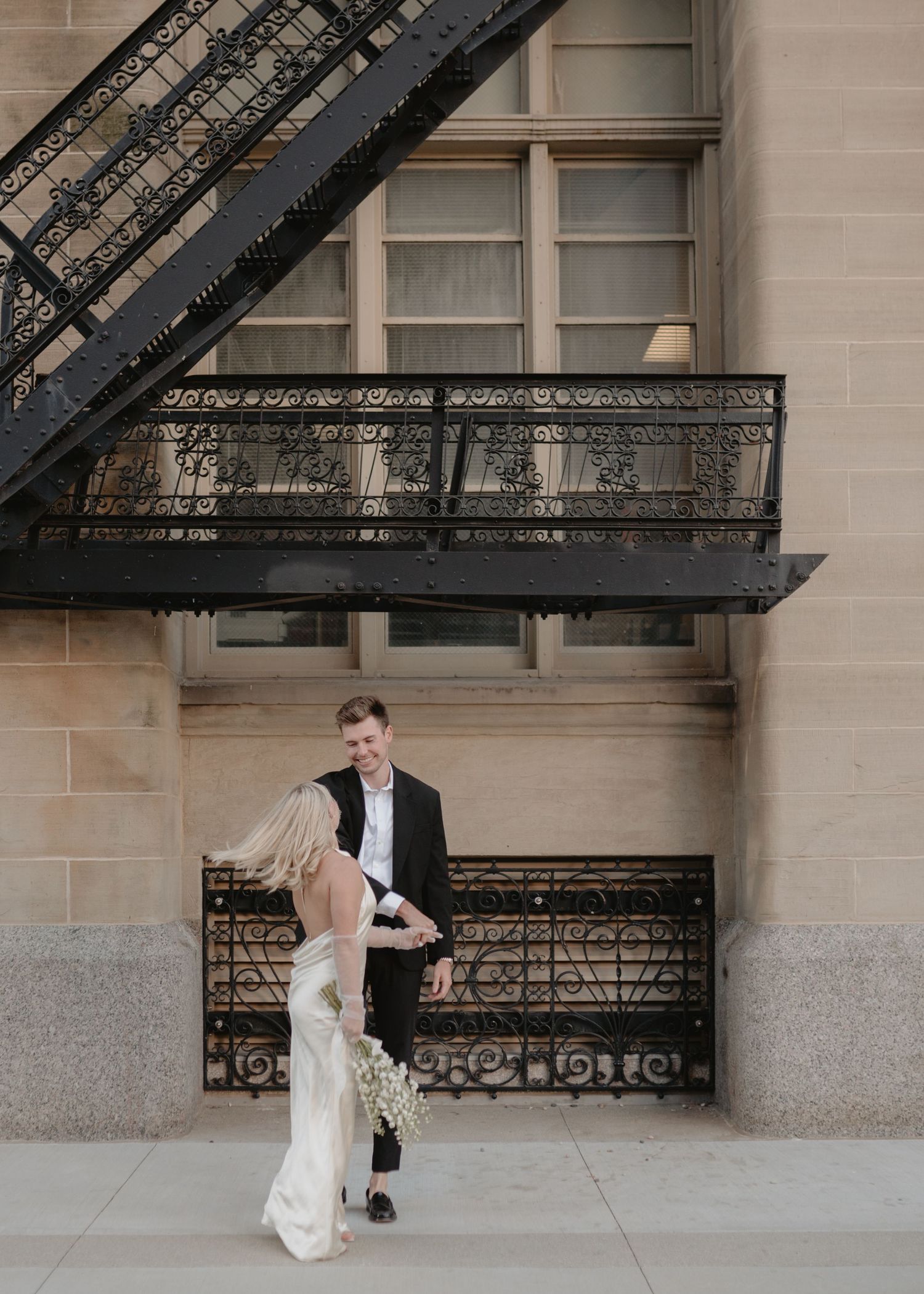 Elegant wedding photography featuring ornate iron railings and stone architecture.