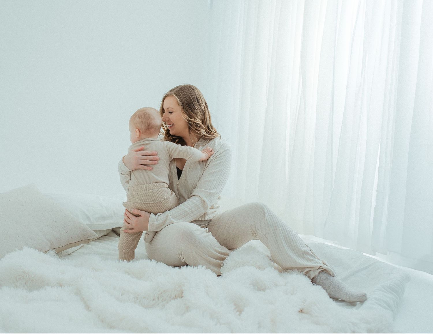 Intimate lifestyle photos captured on white bedding in soft natural light.