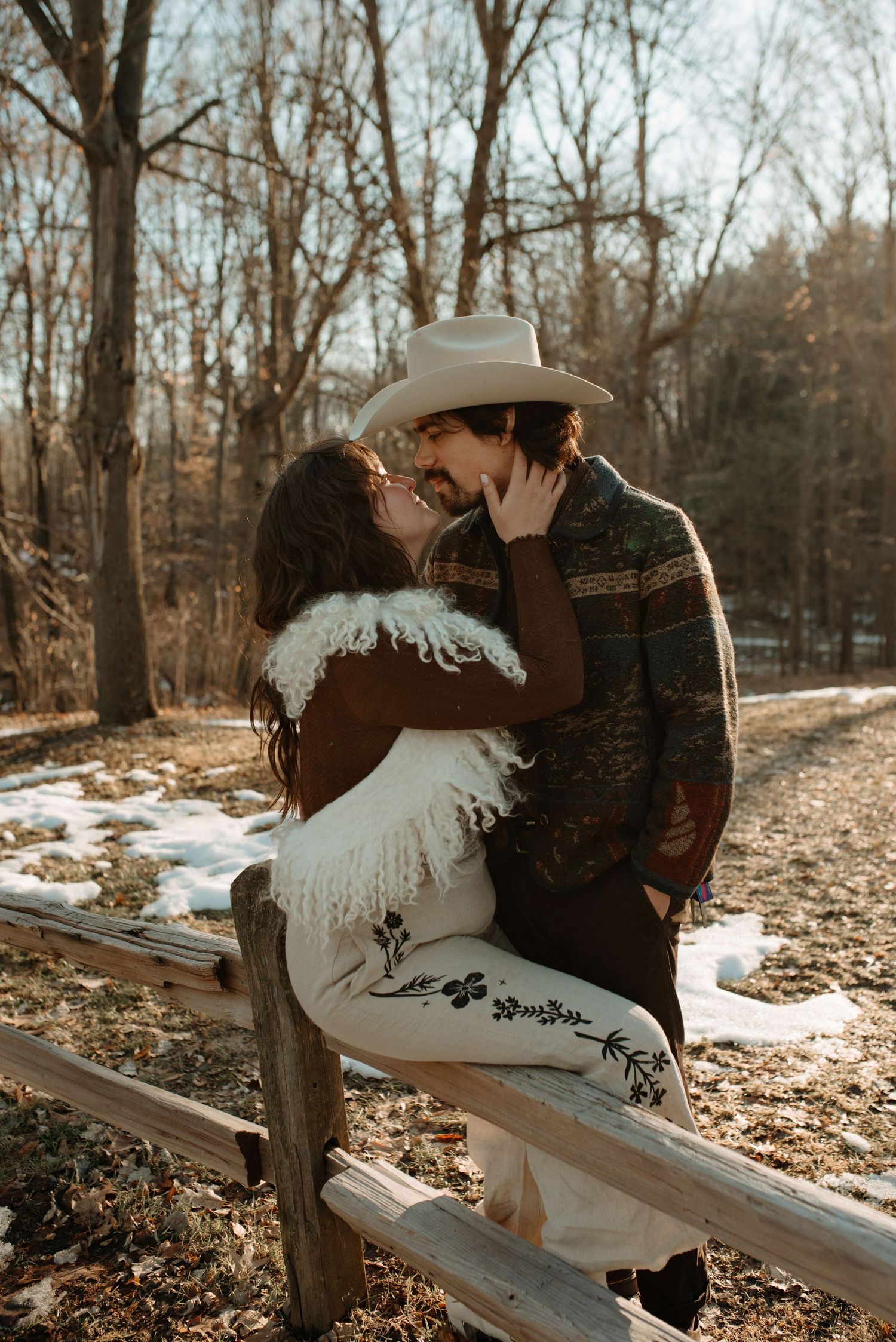 Romantic winter scene with rustic wooden fence and snow-covered ground.