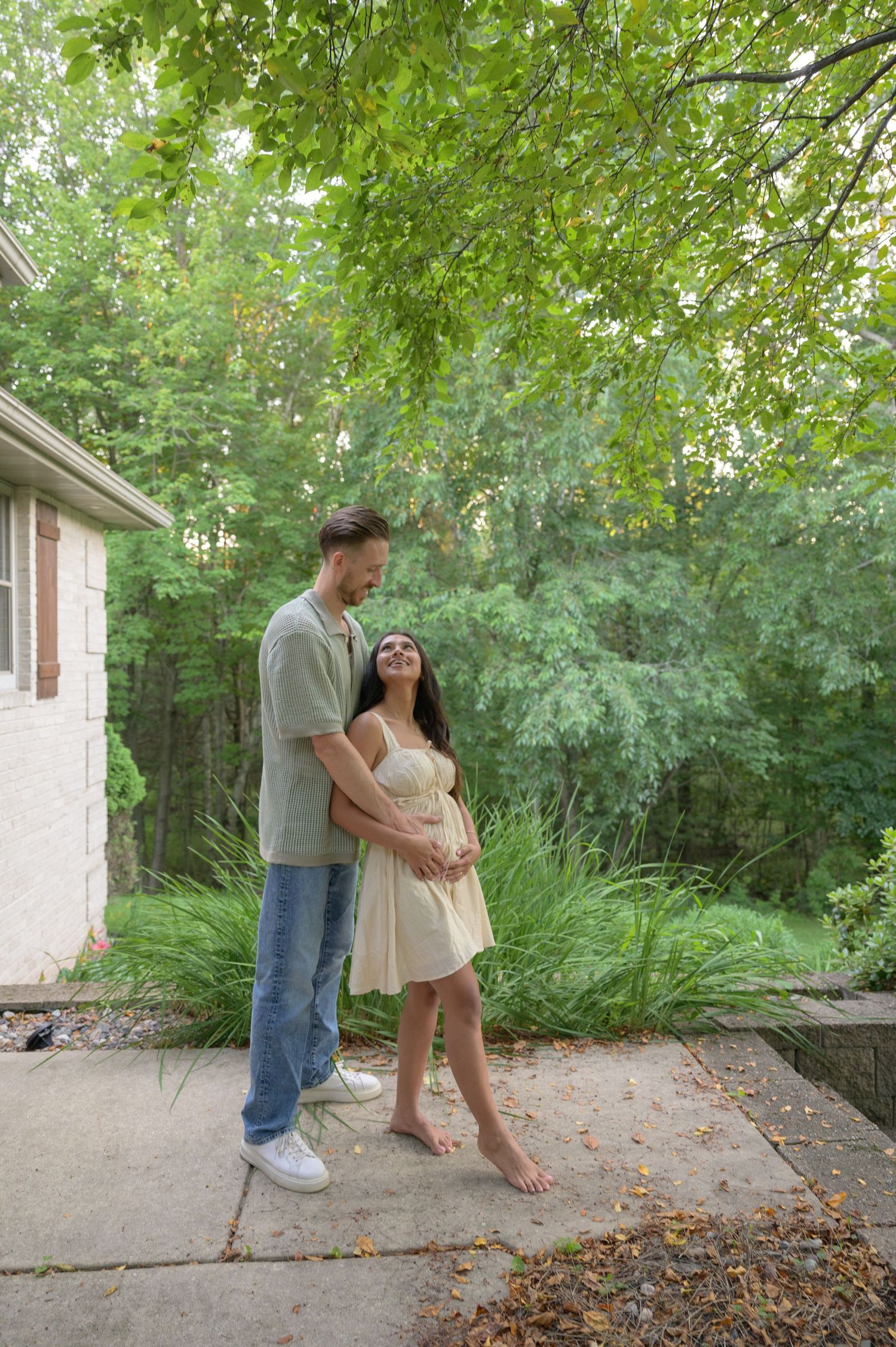Couple standing together on patio surrounded by lush summer greenery. Appleton, Green Bay & Kaukauna
