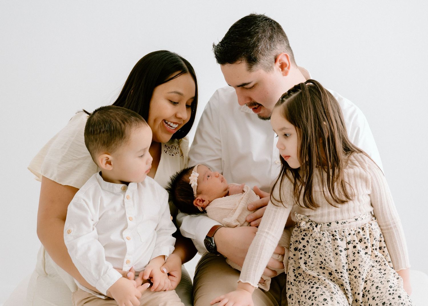 Intimate family portrait session against a clean white background.