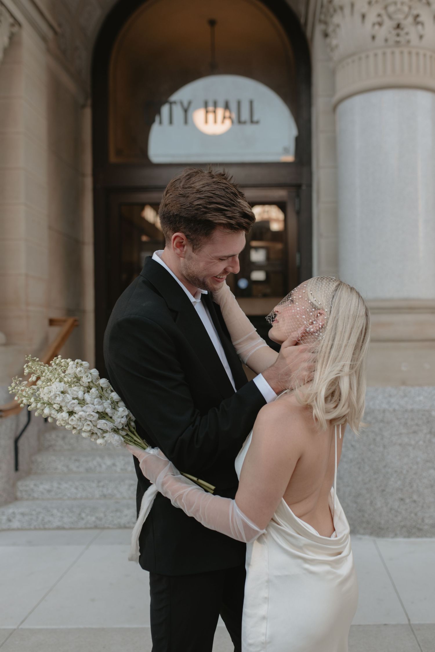 A romantic wedding couple shares intimate moments in a series of black and white photos at City Hall. Appleton, Green Bay & Kaukauna